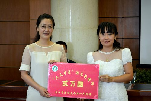 招生就业处处长陈冬梅(左)代表学校接受“久久中医”励志奖学金