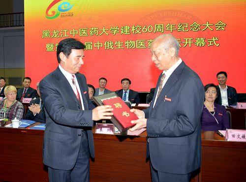 校党委书记袁纲为段富津教授颁发“终身教授”聘书,同时授予其“国医大师终身成就奖”